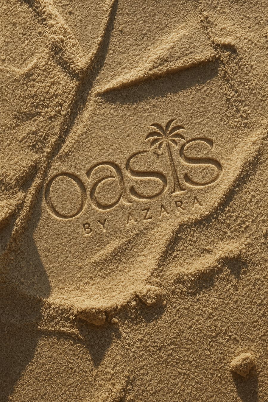 The Oasis by Azara mark pressed into golden sand